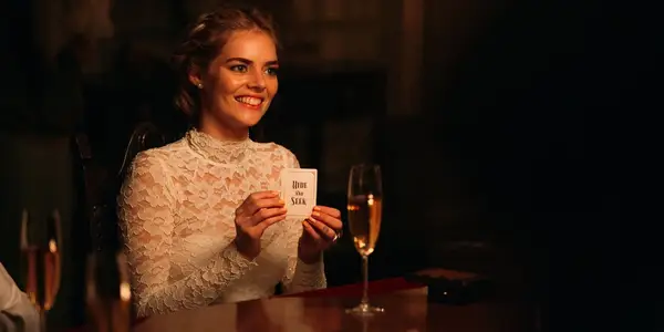 Samara Weaving holding the hide and seek card in Ready or Not