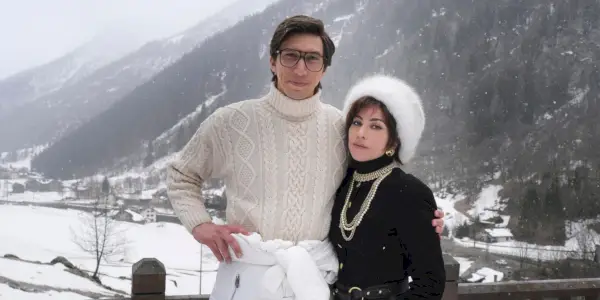 Lady Gaga y Adam Driver en House Of Gucci vistiendo ropa de invierno con un fondo nevado.