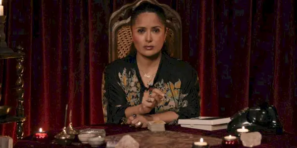 Giuseppina está sentada en una mesa rodeada de velas en House of Gucci.