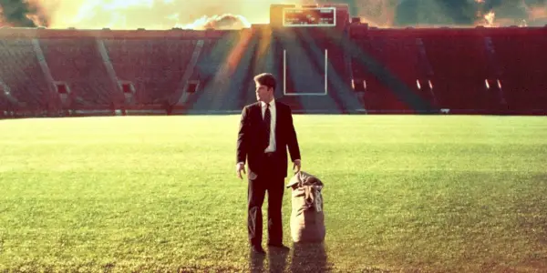 Sean Astin in piedi su un campo di calcio con una borsa di Rudy