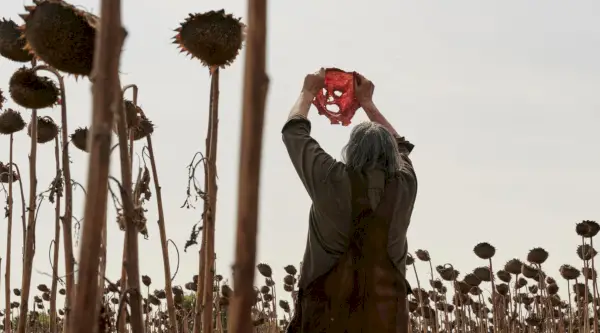 Mark Burnham jako Leatherface podczas masakry piłą mechaniczną w Teksasie podnosi maskę tyłem do kamery