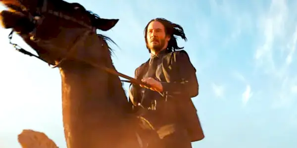 Keanu Reeves rir på en hest i John Wick: Kapittel 4.