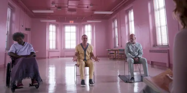 Elijah (Samuel L Jackson), Kevin (James McAvoy) e David (Bruce Willis) in una stanza rosa a Glass