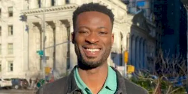 Dotun Olubeko The Bachelorette souriant en chemise verte à l'extérieur de la ville