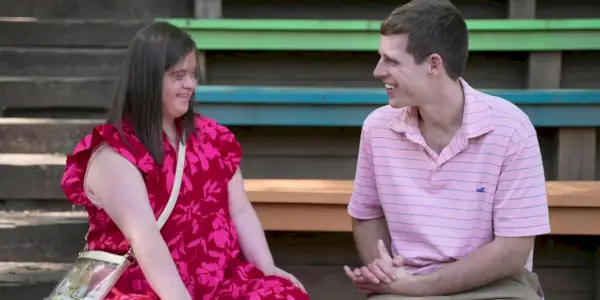 Amor no espectro Tanner Smith e Kate sentados em degraus coloridos