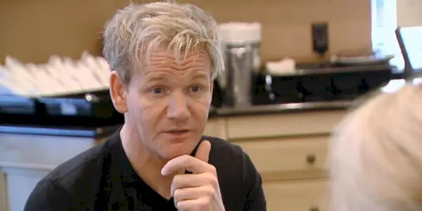 Gordon Ramsay sur Kitchen Nightmares assis en face d'un propriétaire, lui parlant
