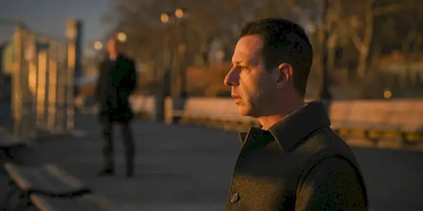Kendall Roy (Jeremy Strong) sa pozerá na rieku s Colinom (Scott Nicholson) v diaľke vo finále série postupnosti