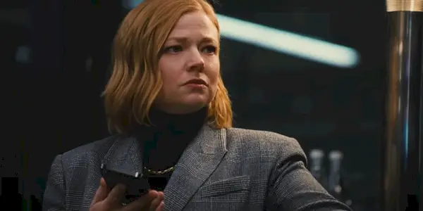 Shiv Roy (Sarah Snook) drží svoj telefón a tvári sa utrápene v 4. sérii Nástupníctva, epizóde 8