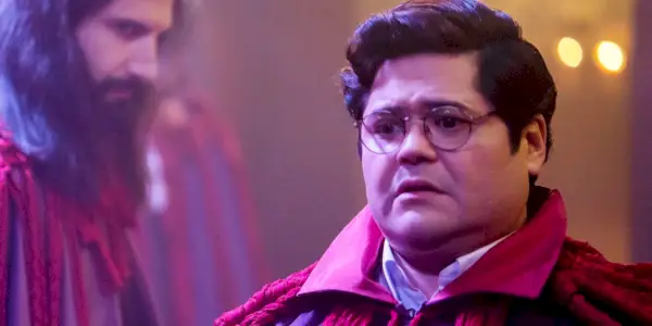 Harvey Guillén vyzerá znepokojene ako Guillermo s Nandorom (Kayvan Novak) v pozadí vo filme What We Do In The Shadows