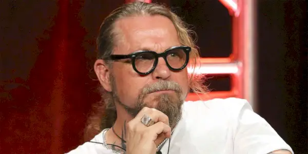 Kurt Sutter sentado e olhando para alguma coisa.