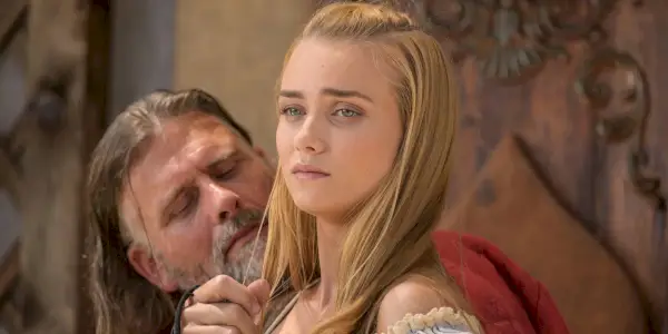 Tiana Upcheva distoglie lo sguardo disgustata mentre un uomo le accarezza i capelli