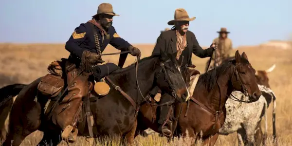 LaMonica Garrett ako Thomas a Sam Elliott ako Shea jazdia na koňoch v roku 1883