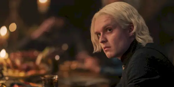 Aegon parecendo irritado em uma mesa
