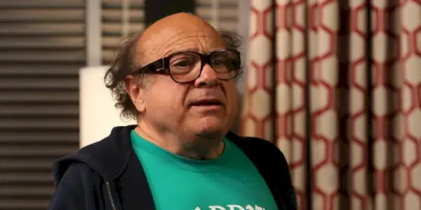 Frank trägt darin einen Kapuzenpullover und ein grünes Hemd