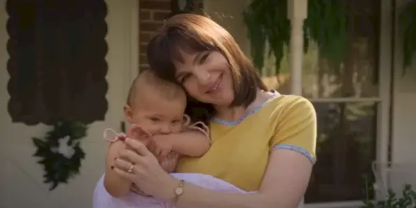 Lily Rabe hält ein Baby und lächelt in Love & Death