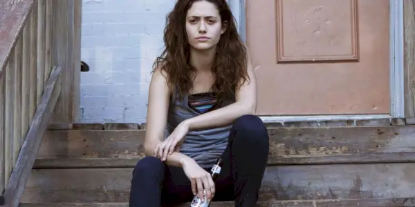 Fiona Gallagher siedzi na schodach i trzyma butelkę w Shameless