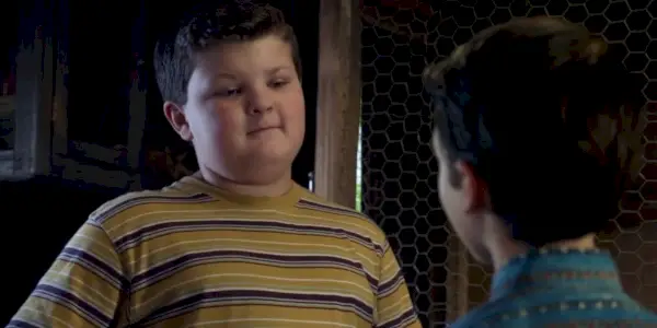 Billy Sparks di Young Sheldon indossa una maglietta a righe e guarda Sheldon.