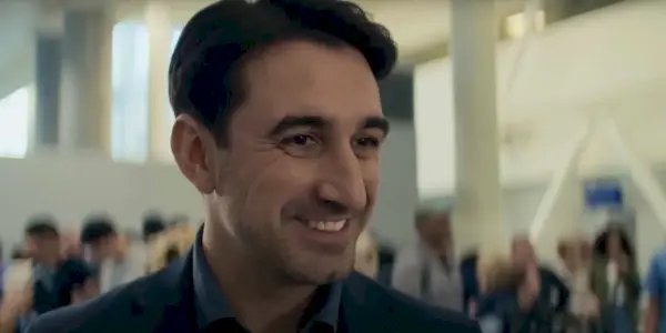 Ferdinand Kingsley sonriendo como AM en la temporada 2 de Reacher