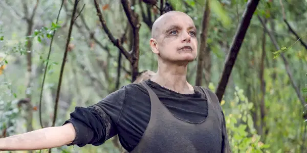 Alpha de The Walking Dead de pie con los brazos extendidos.