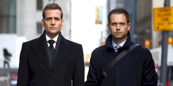 Harvey a Mike na ulici v oblekoch.