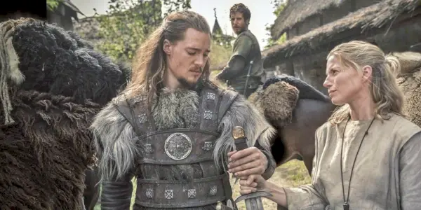 Alexander Dreymon como Uhtred y una mujer sosteniendo una espada en The Last Kingdom
