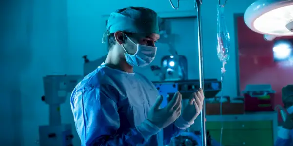 Dr. Smrt, Christopher Dunsch, drží ruce v rukavicích na operačním sále