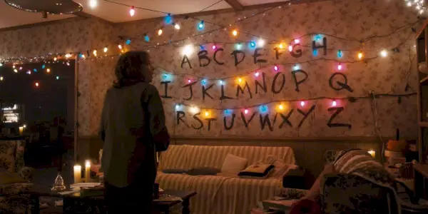 Joyce hľadí na svetlá na stene v Stranger Things