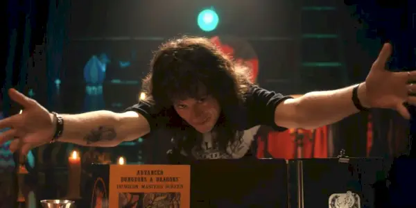 Joe Quinn como Eddie Munson extendiendo sus manos en la cuarta temporada de Stranger Things
