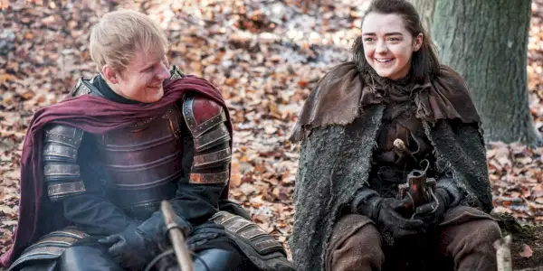 Ed Sheeran a Maisie Williamsová se smějí, když sedí na zemi ve hře Game of Thrones