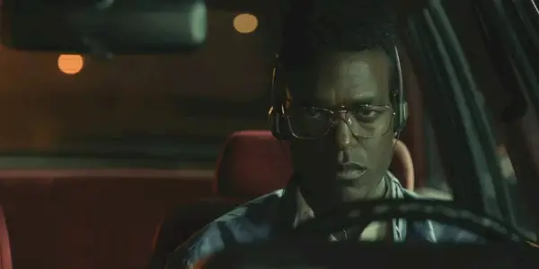 Edmund vyzerá nahnevane, keď šoféruje auto so slúchadlami na ušiach