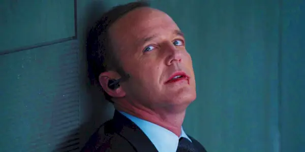 Clark Gregg como Phil Coulson com sangue no rosto sendo morto por Loki em Os Vingadores (2012)