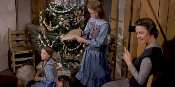 Rodina otevírá své dárky u ozdobeného stromečku v Little House on the Prairie epizoda Vánoce u Plum Creek