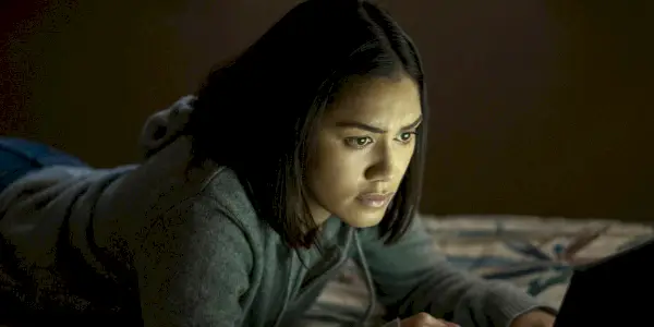 Rose ligger på sengen og ser på en dataskjerm i The Night Agent sesong 1.