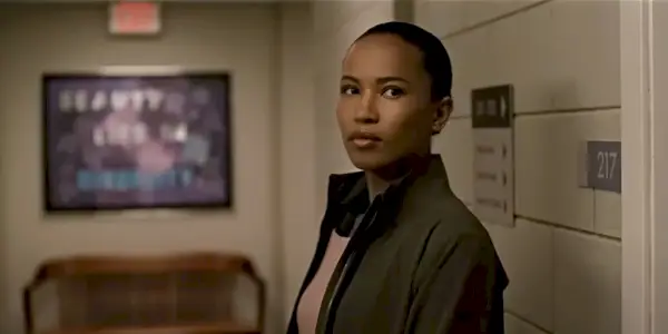 Chelsea ser alvorlig ut mens han står i gangen i The Night Agent.