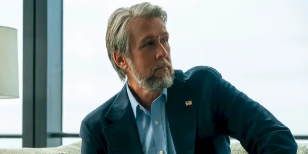 Roman Roy em Sucessão gesticulando atrás de uma mesa