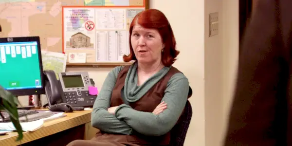Kate Flannery jako Meredith Palmer se skepticky dívá na svůj stůl v kanceláři