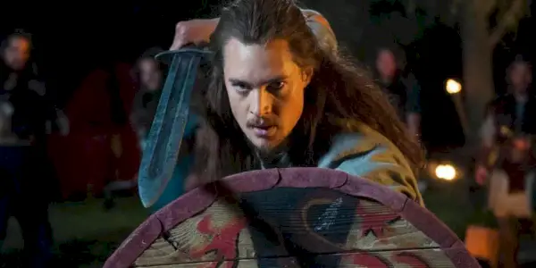 Alexander Dreymon dans le rôle d'Uhtred tenant une épée et un bouclier dans The Last Kingdom