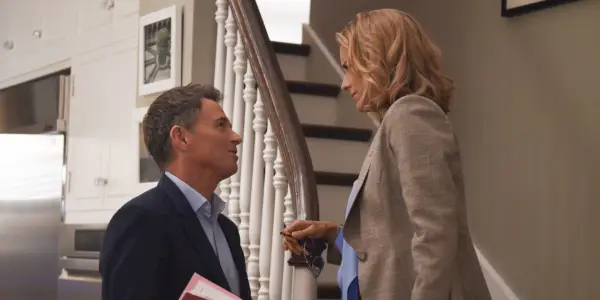 Tim Daly stojí dole, zatímco Tea Leoni stojí na schodech v Madame Secretary