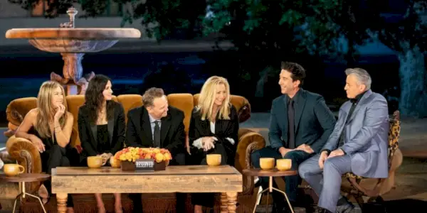 Uma imagem do elenco conversando no sofá na Reunião de Amigos