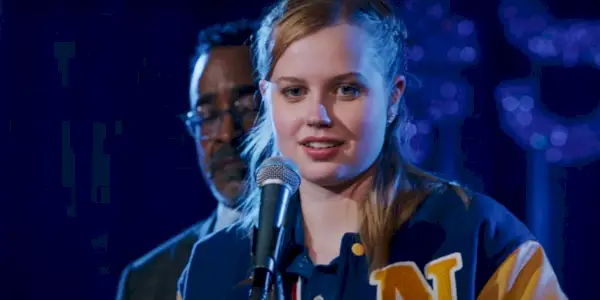 Angourie Rice como Cady Heron parada frente al micrófono en Mean Girls 2024.webp