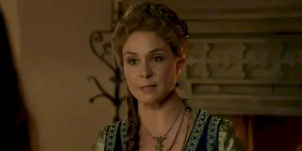 Catherine rozmawia z kimś przed kominkiem w Reign
