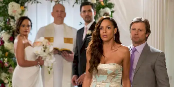 Spence Westmore (Grant Show), Rosie (Dania Ramirez) und Zolia (Judy Reyes) sehen jemanden geschockt an, während Rosie in Devious Maids am Traualtar steht und heiratet.