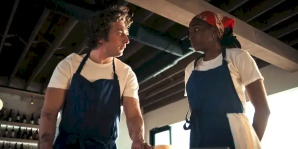 Carmy (Jeremy Allen White) und Sydney (Ayo Edibiri) schauen sich in „The Bear“ in ihren Kochuniformen an.