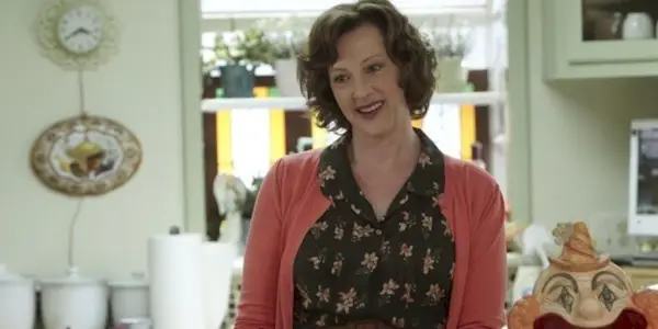 Sheila con una sonrisa extraña en la cocina en Shameless.