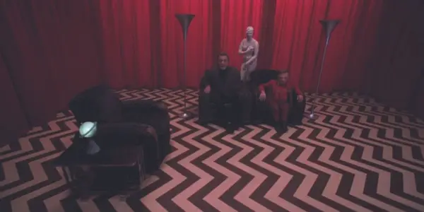Deux hommes sont assis sur un canapé dans la salle rouge de Twin Peaks Fire Walk With Me.