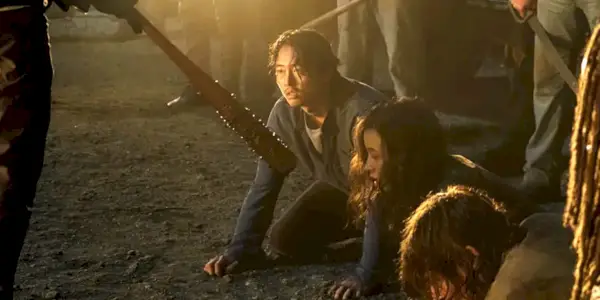 Steven Yeun knæler på jorden, mens Glenn ser på et baseballbat i The Walking Dead sæson 7.