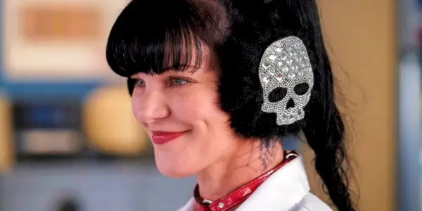 Pauley Perrette nosí klapky na uši a usmívá se jako Abby Sciuto v NCIS