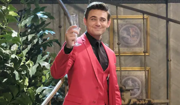 Johnny in abito rosso si trova sulla scala DiMera. I suoi occhi sono giallo diavolo. Sorride e solleva un flauto di campagna. Giorni della nostra vita