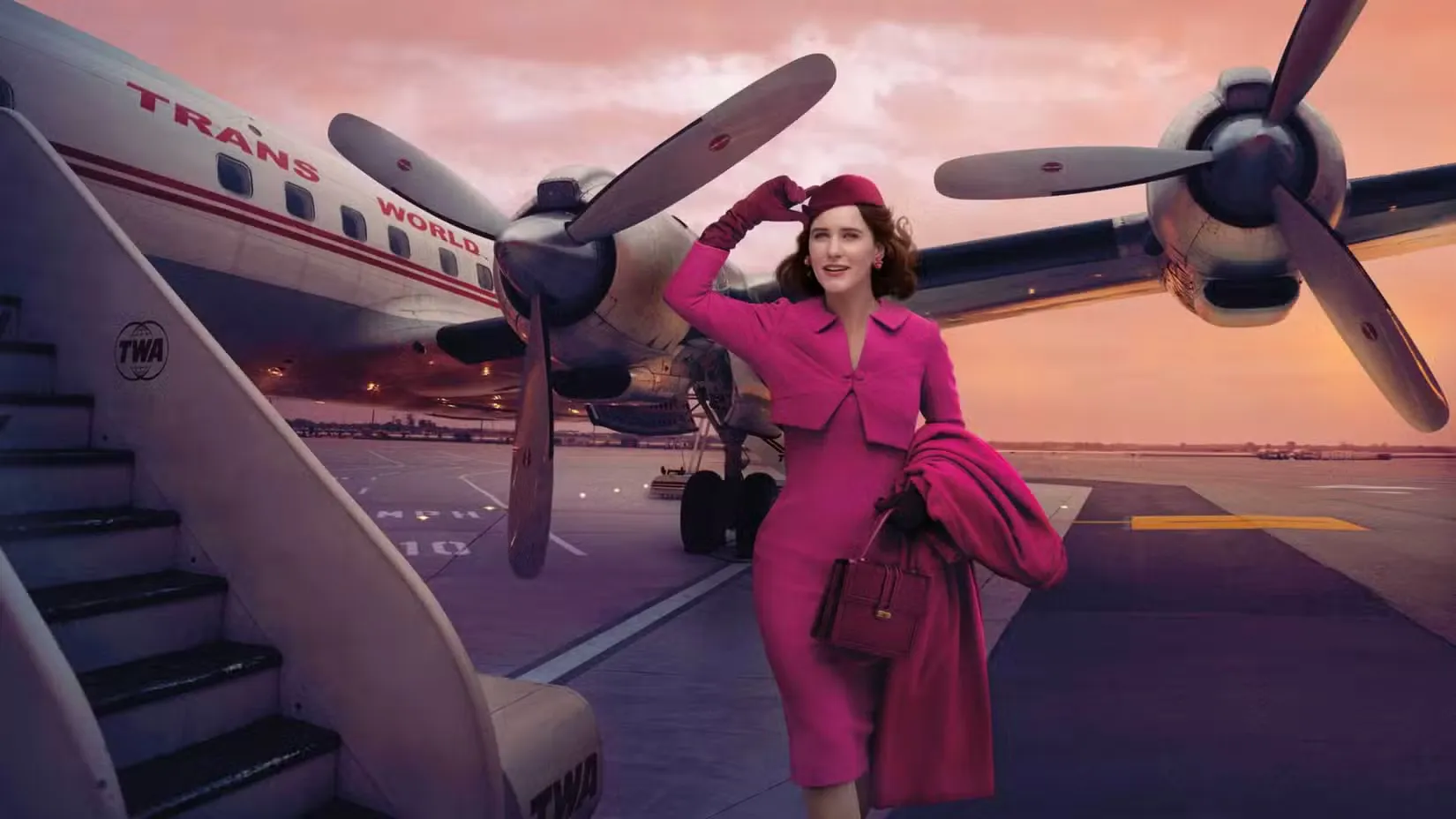 Мідж Мейзел (Рейчел Броснахен) стоїть біля літака у фільмі 