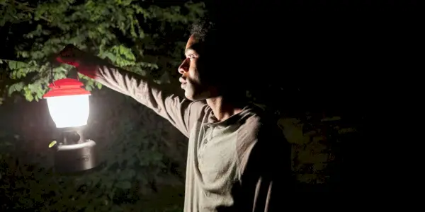 טרוויס מחזיק פנס ביער בלילה ב-It Comes at Night